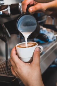 person holding white ceramic mug with coffee