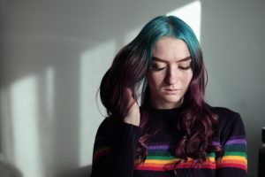 woman holding her hair in white wall paint room